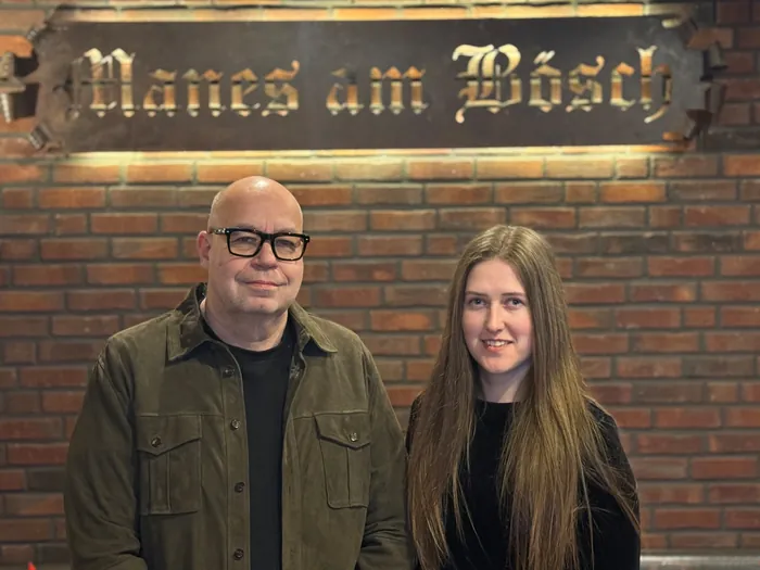 Janina Felbor und Boris Orschel vor dem schmiedeeisernen Schriftzug Manes am Bösch